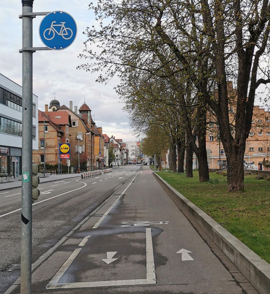City street with a marked bike lane and bicycle traffic sign